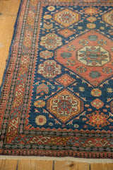 Complex border of an antique Tehran rug showing geometric Caucasian patterns in indigo and madder red.