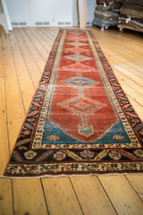 Antique Bakshaish runner with geometric diamond medallions and an abrashed pomegranate field.