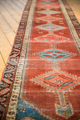 Angled detail of antique Bakshaish runner showing abrashed pomegranate field, sky blue diamond motifs, and visible wear with low pile.