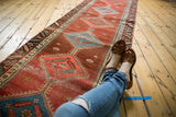 Antique Bakshaish runner with diamond medallion, abrashed pomegranate field, sky blue, and soft low pile.
