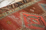 Abrashed cochineal pomegranate field of antique Bakshaish runner with low pile and blush pattern.