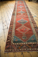 Secured end of the antique Bakshaish runner, showing low pile, tribal borders, and pomegranate field.