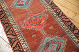 Sky blue diamond medallion and red motifs, showing low pile and wear, on antique Bakshaish runner.