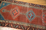 Interlaced diamond medallions in alternating colors on abrashed pomegranate antique Bakshaish runner.