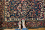 Antique Kurdish Bijar rug with navy Herati field, blush diamond medallion, and rams horn motifs.
