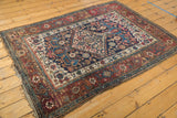 Angled detail of antique Kurdish Bijar rug's intricate Herati field and multi-tone borders.