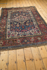 Antique Bijar rug's lower wine red border, blue stripe, geometric patterns, and natural fringe.