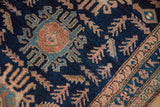 Navy blue field detail of the Hamadan rug, featuring abstract figures and plant motifs.