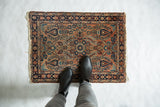 Vintage Lilihan rug's central floral design and blossomed field in dusty rose and navy.