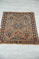 Vintage Lilihan rug corner detail, with navy border, dusty rose field, and tatter.