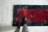 Art Deco Chinese runner, deep wine red field, navy border, butterfly, and visible white knots.