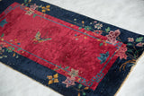 Angled view of Art Deco Chinese runner: deep red field, butterfly, floral details, tattered end.