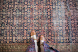 Worn navy and blush Herati pattern on an antique Malayer runner with visible repair.