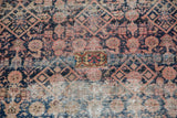 Exposed foundation, visible knot heads, and floral patch on the worn antique Malayer rug.