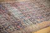 Antique Malayer rug's worn Herati motif and distinct patterned repair in navy and red blush.