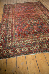 Antique Malayer rug end with light tatter fringe, showing intricate madder red, ivory, and teal patterns.