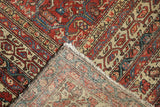 Antique Malayer rug folded corner, showing madder red pile wear and hand-knotted foundation.