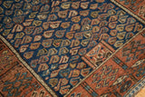 Antique Kurdish rug corner: cobalt blue field, unique boteh motifs, and madder red border.