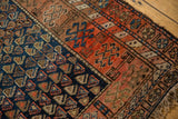 Antique Kurdish rug close-up: cobalt blue field with light boteh, madder red with geometric motifs.