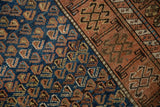 Kurdish rug detail: vibrant cobalt blue field with boteh, transitioning to madder red geometric border.