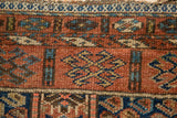 Antique Kurdish rug showing fine knotted texture, varied boteh motif, and light tatter to selvage.