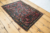 Hand knotted Lilihan rug corner showcasing plum, blue, and gold floral patterns, low pile.