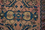 Antique Lilihan rug's blush, indigo, and brown Mahi floral motifs with exposed knot heads.