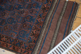 Antique Belouch rug's intricate indigo and madder red pile with striped plain woven foundation.