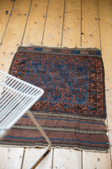 Lower end of antique Belouch rug with striped plain woven foundation and fringe.