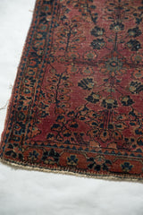 Bottom end of antique Mohajeran Sarouk, showing wear, faint foundation, plum, navy floral motifs.