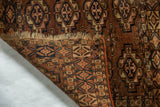 Aged fringe and geometric patterns on antique Turkmen tent cover in chestnut, navy.