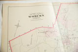 Title block, compass rose, and pink boundary on an antique 1875 Woburn, MA atlas map.