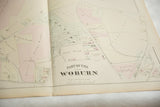 Angled view of the antique Woburn atlas map showing the center fold and landowners' properties.