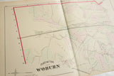 Angled view of the Woburn, MA atlas map detailing the railroad and hand-colored land plots.