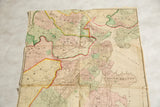 Antique 1874 map of Boston showing colored wards around Boston Harbor and visible paper folds.
