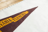 Detail of the vintage Pennsylvania Turnpike pennant's frayed dark red felt tip and yellow lettering.