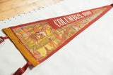 Faded red and yellow felt Columbus, Ohio pennant showing Indian village illustration and text.