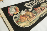 Close-up of a vintage felt pennant's illustration of a Native American and schoolhouse.