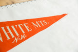 Vintage orange felt pennant tip displaying cream 'MTS. N.H.' text and aged texture.