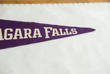 Vintage purple felt pennant tip with cream block lettering and a small, visible pinhole.