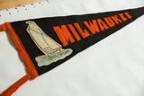 Felt sailboat graphic and orange 'MILWAU' lettering on antique Milwaukee pennant.