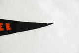 Antique black felt pennant's pointed tip, showing slight loss and partial orange letters.