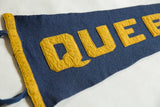 Angled close-up of the sewn yellow felt letters and border on the blue Quebec pennant.