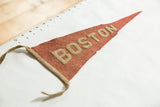 Time-softened red felt Boston pennant with beige BOSTON lettering.