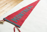 Vintage Montreal felt pennant detail, showing faded blue 'MONTREAL' lettering and red ties.