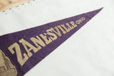 Vintage purple felt pennant showing cream ZANESVILLE OHIO lettering.