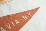 Orange felt Batavia N.Y. pennant's pointed end, showing light 'N.Y.' letters and texture.