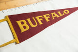 Maroon felt Buffalo pennant with bold golden letters, yellow side trim, aged texture.