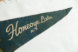 Green felt pennant detail with cream text and visible creasing on its worn tip.