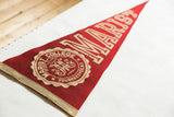 Marist College emblem on faded red felt pennant, showing worn beige edge.